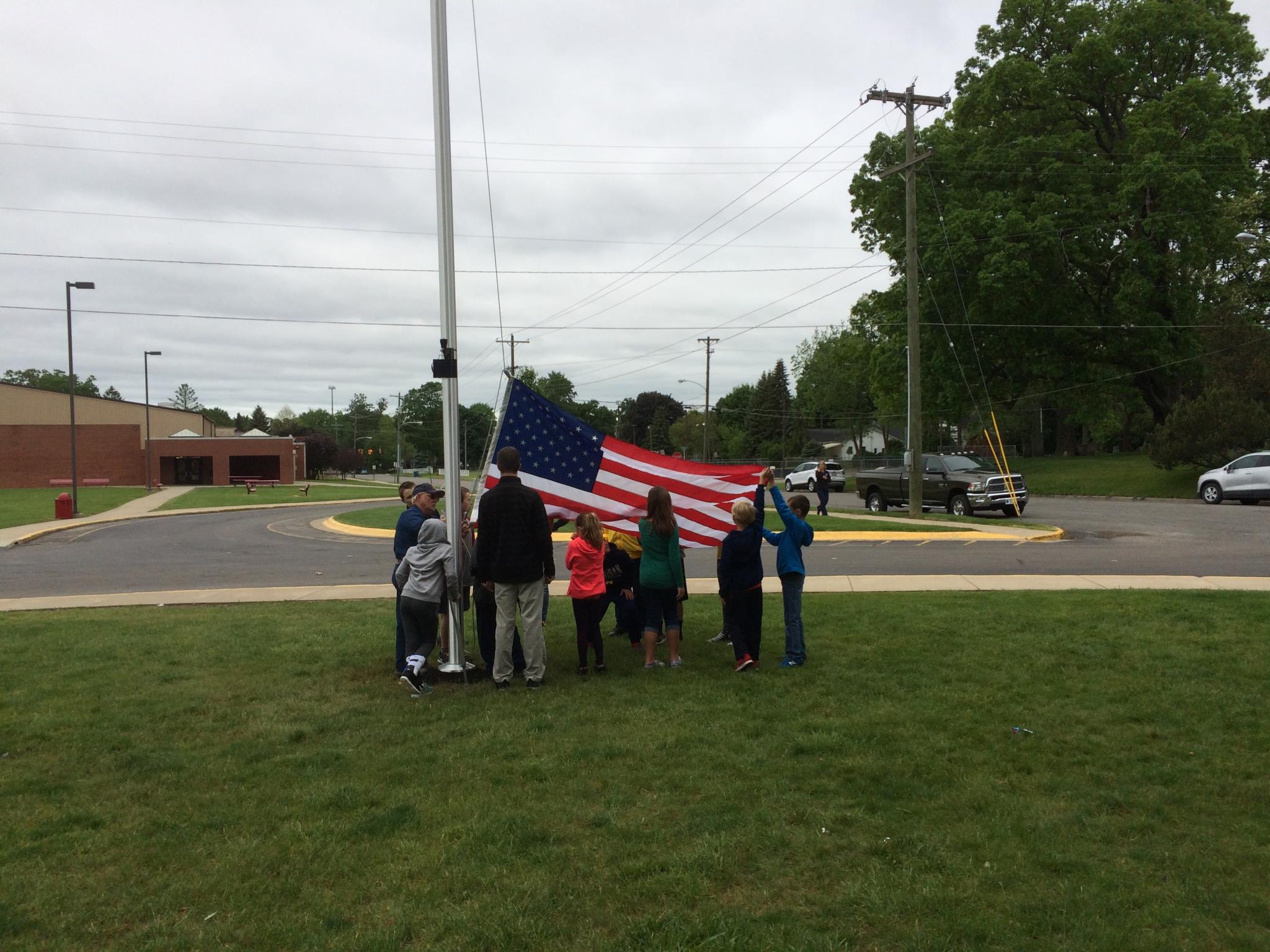 Students and Staff gather around new flag and flag pole